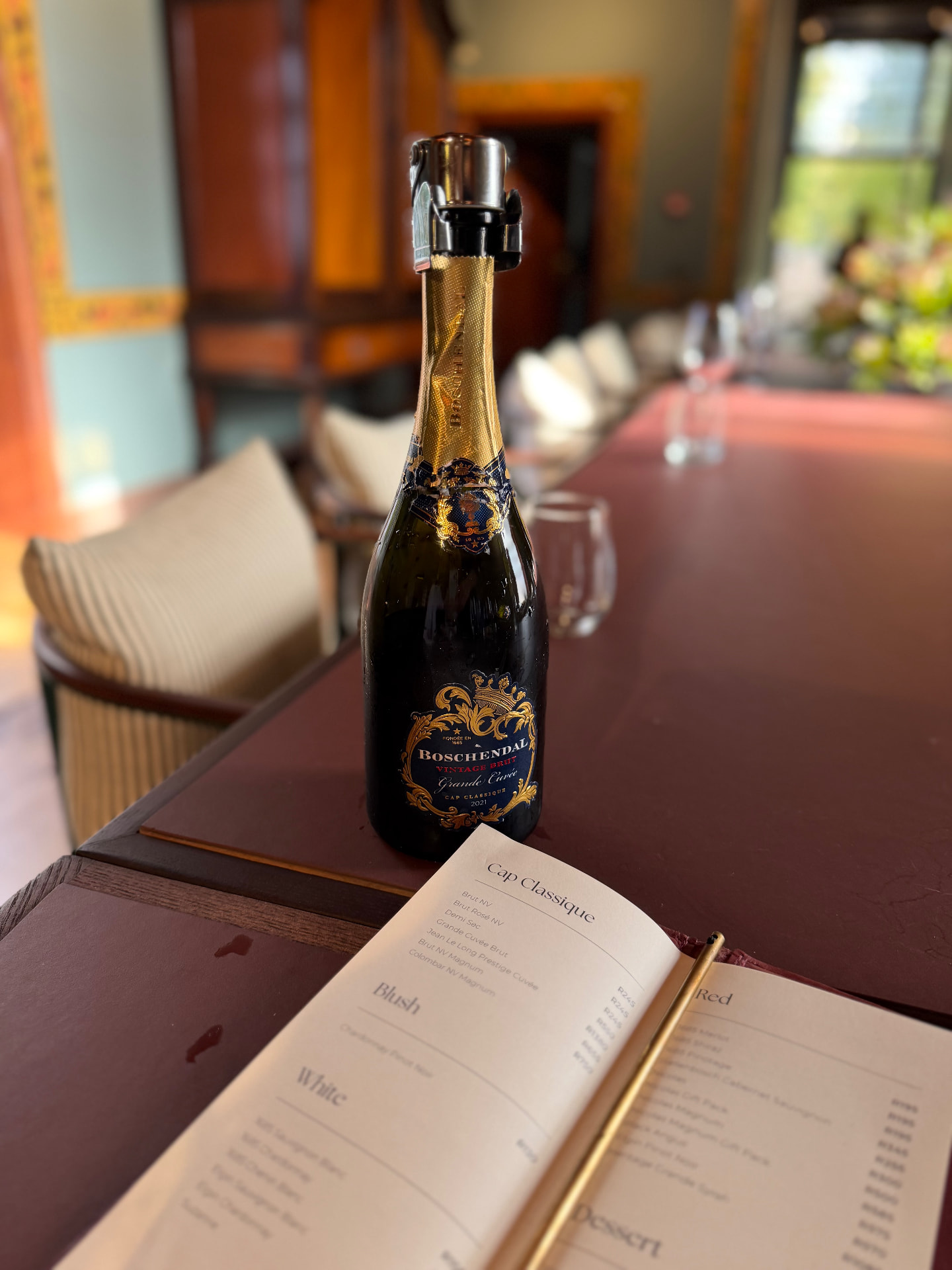 Cap Classique on a long dining table with the wine list open